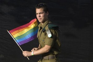 An Israeli soldier holds a flag as he takes part in the gay pride parade in Jerusalem