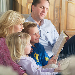 Family Reading a Bible and a Book Together